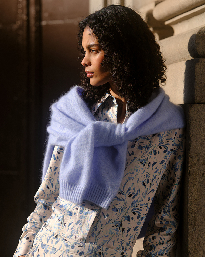 Woman in floral shirt and skirt with blue knit