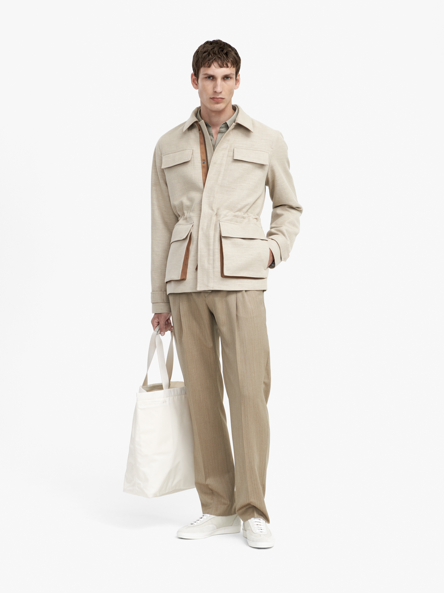 Man in beige trousers and light beige jacket