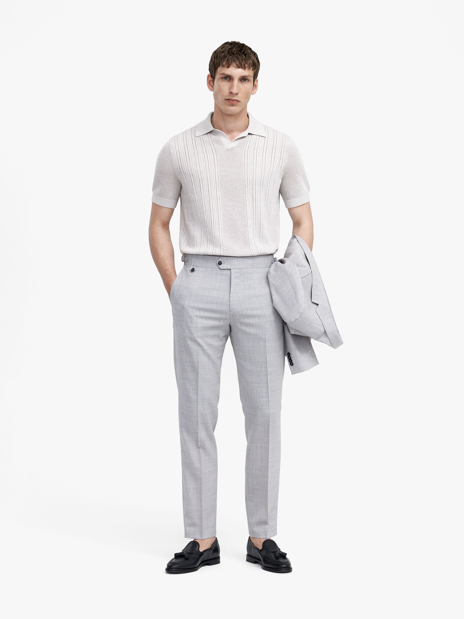 Man in grey trousers and white knit
