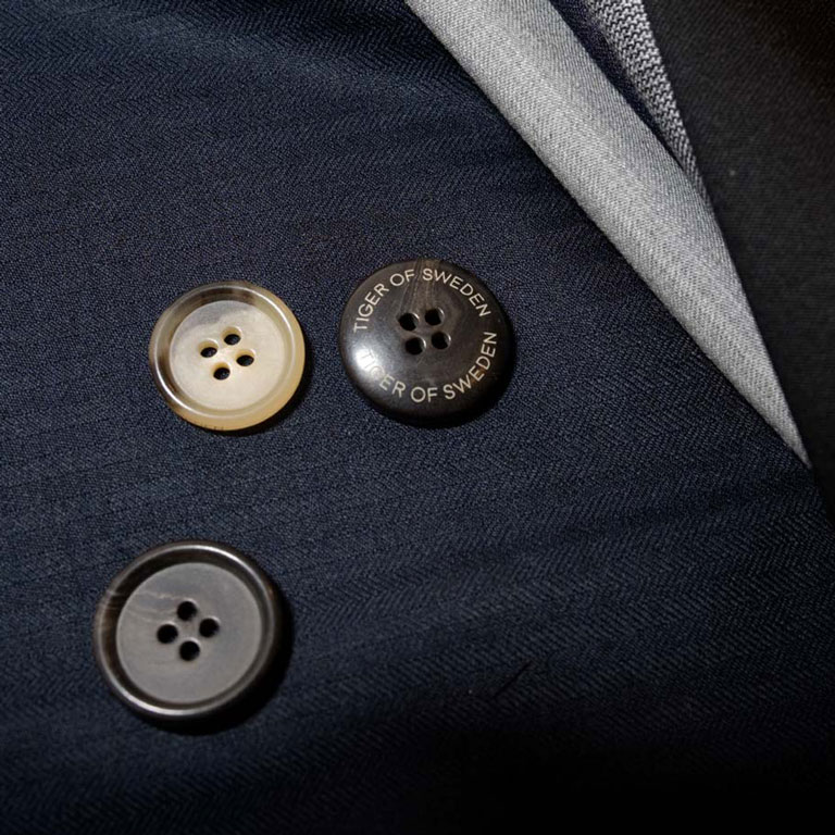 a close up of two buttons on a suit.