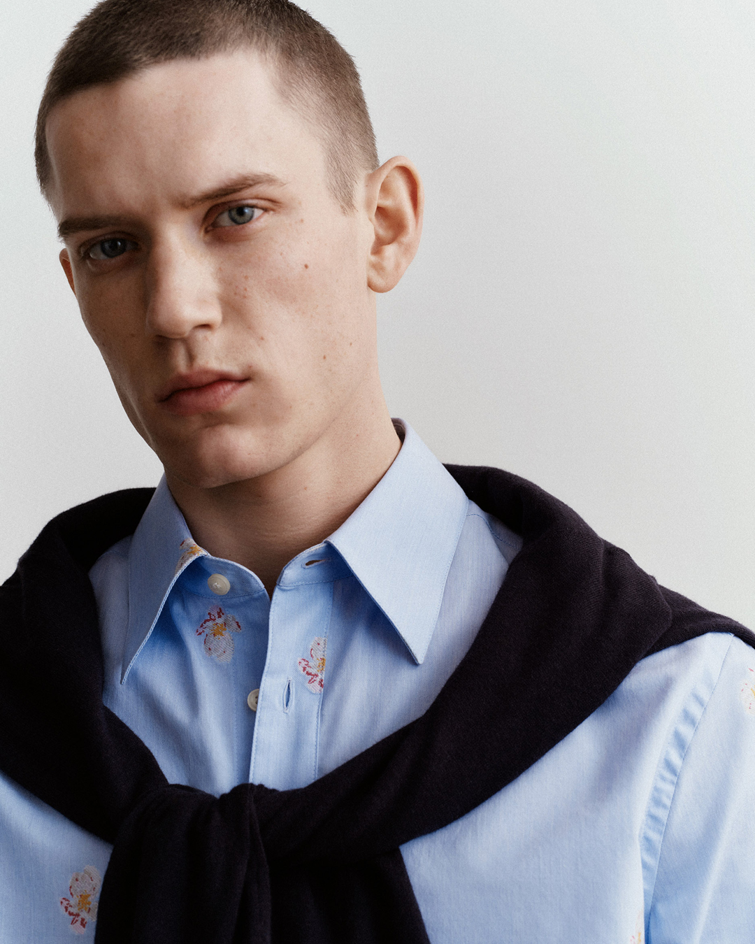 man in blue shirt and knitwear