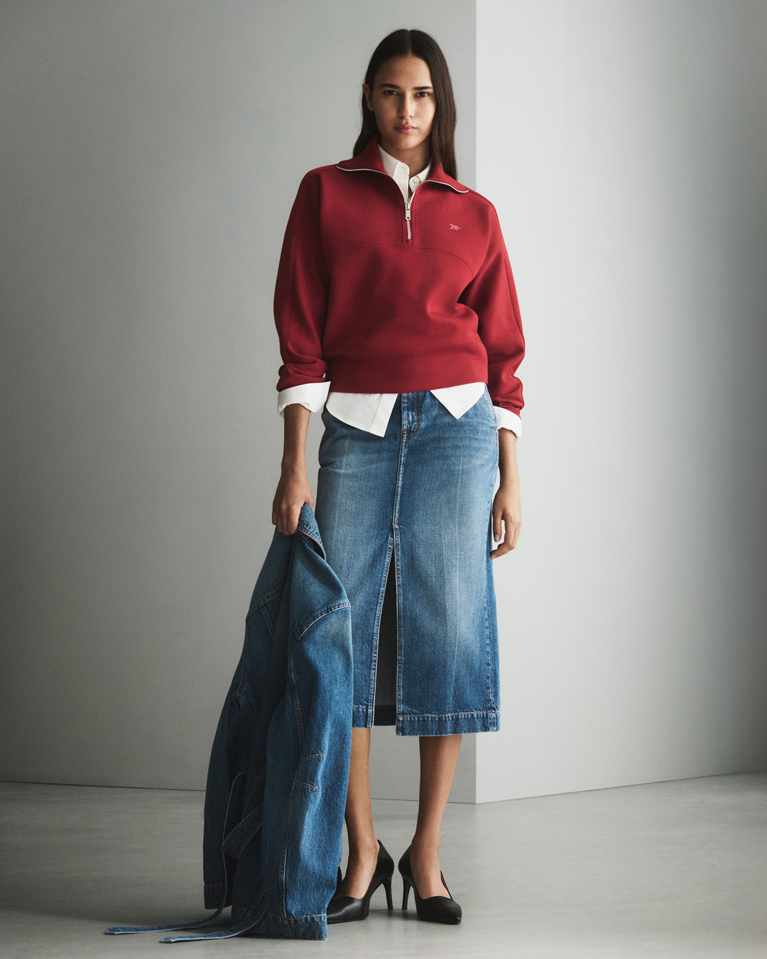 Woman in denim skirt and red pullover