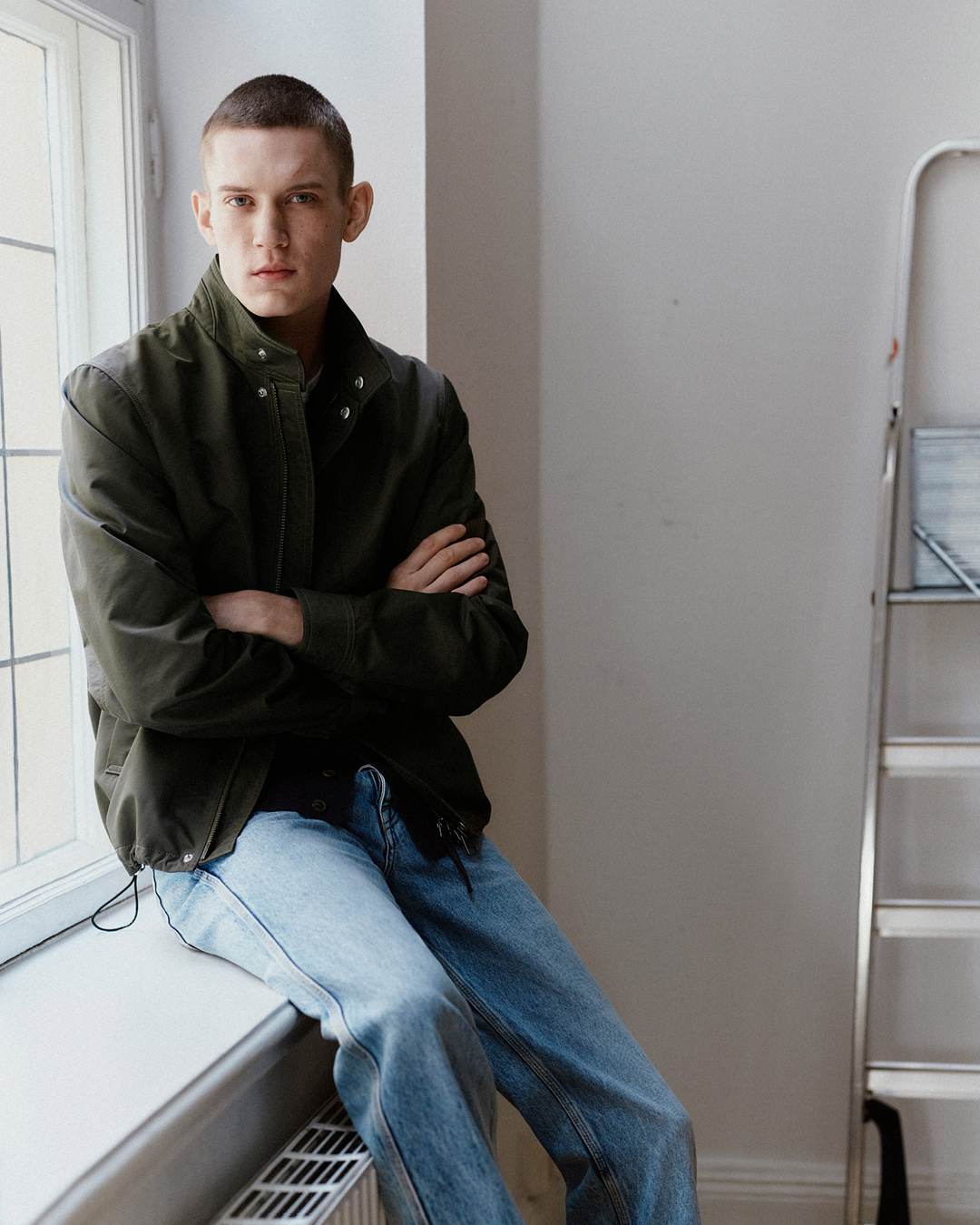 man in blue denim and green jacket