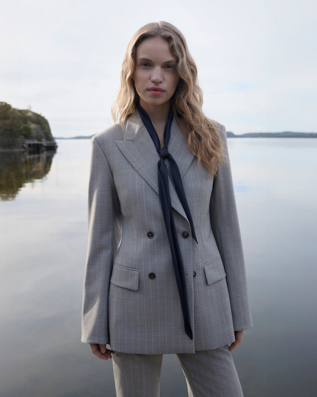 woman in grey suit jacket and scarf