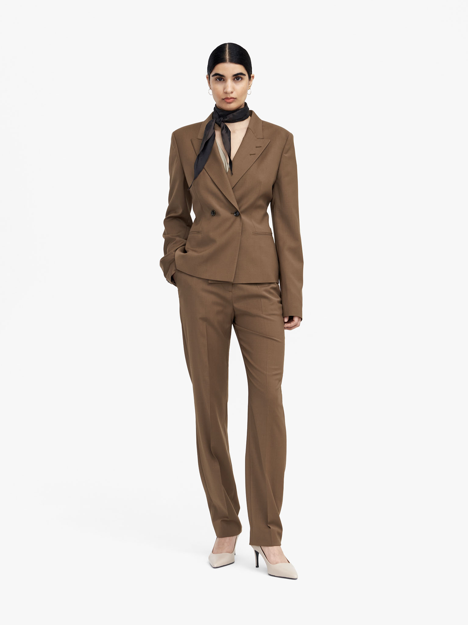 Woman in light brown suit with scarf