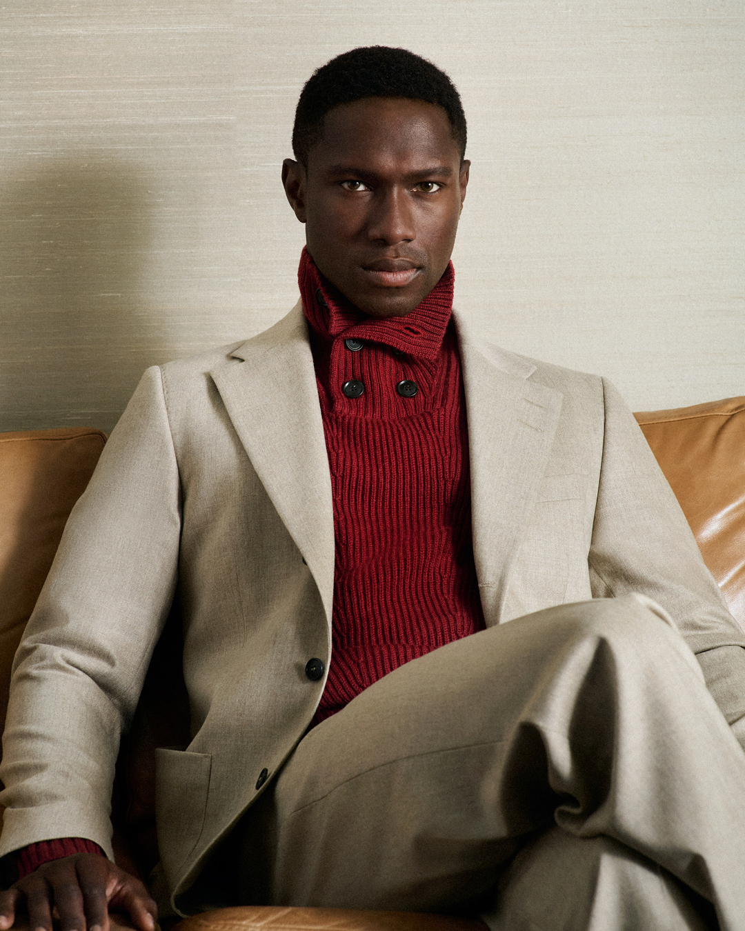 Man in beige suit and red knit