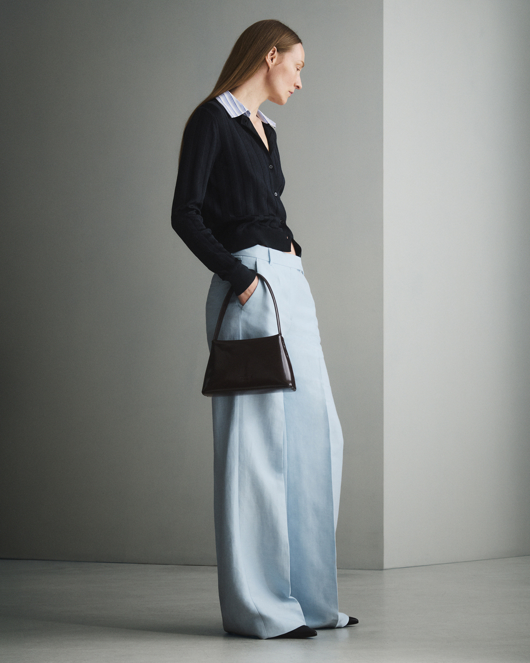 Woman in blue trousers and black knitwear