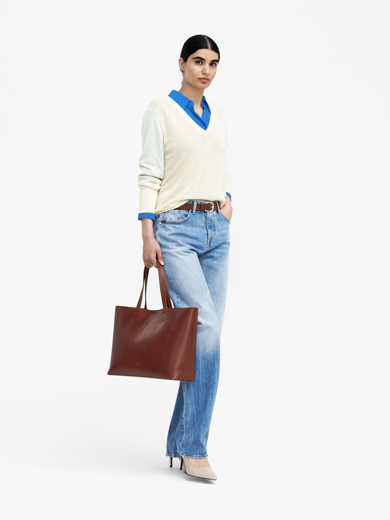 Woman in blue jeans with brown bag