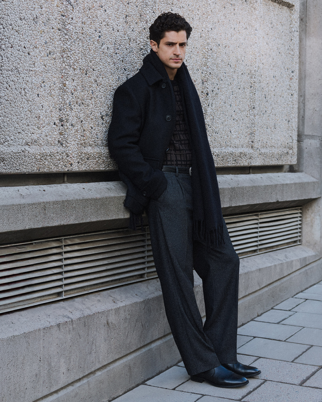 man in trousers and knitwear