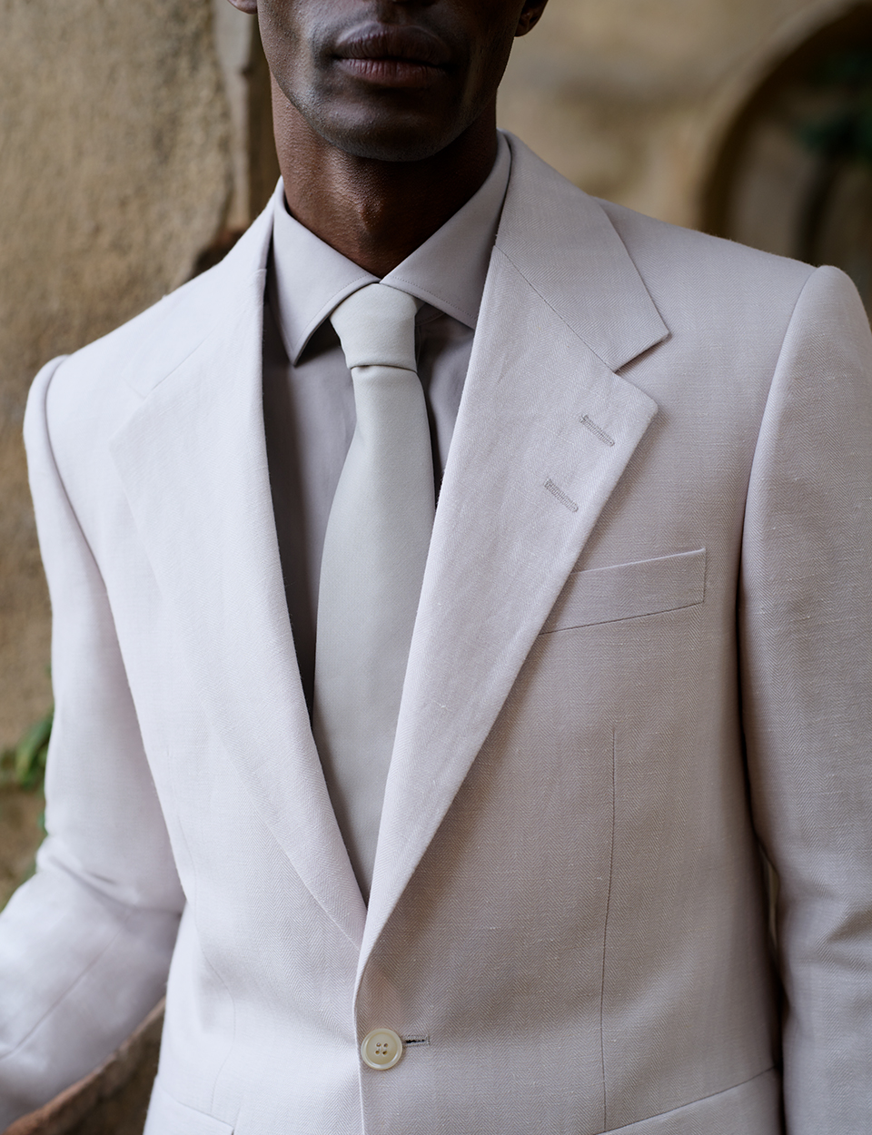 main in white beige suit jacket and tie
